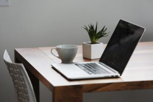 A laptop and cup on a table